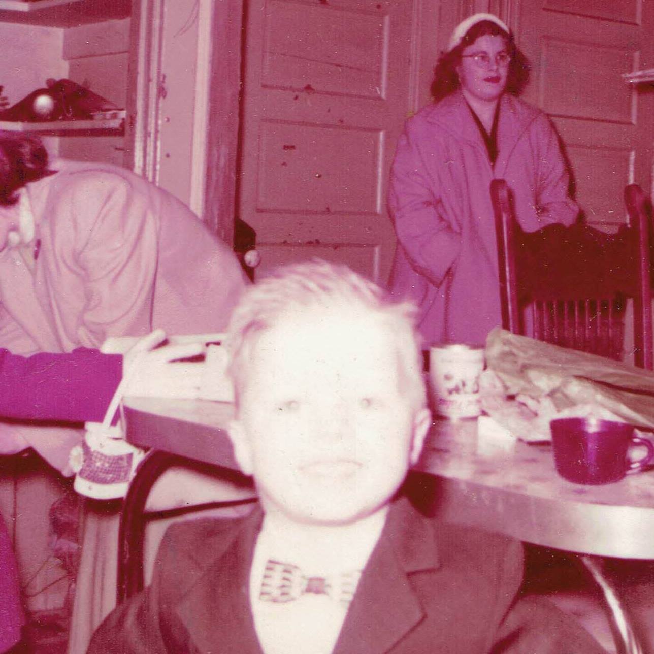 a young hockey_man about five years old in a suit and bow tie, smiling as if it was his birthday or something